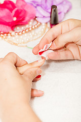 Image showing The esthetician removes the old nail polish with a cotton and remover