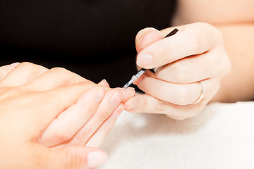 Image showing Laying nail polish on a woman\'s hands