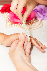 Image showing The beautician polish the client\'s nails before putting nail polish