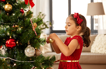 Image showing little girl decorating christmas tree at home