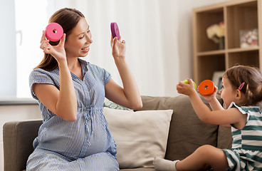 Image showing pregnant mother and daughter with toy blocks