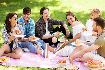 Image showing happy friends eating sandwiches at summer picnic