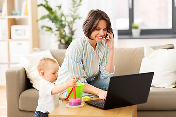 Image showing working mother with baby calling on smartphone