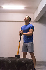 Image showing man workout with hammer and tractor tire