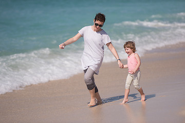 Image showing mother and daughter running on the beach