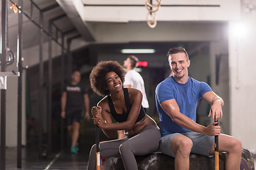 Image showing multiethnic couple after workout with hammer