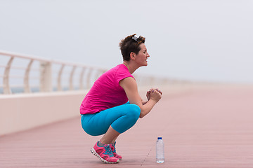 Image showing woman stretching and warming up on the promenade