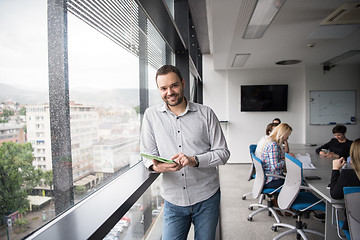 Image showing Businessman Using Tablet In Office Building by window