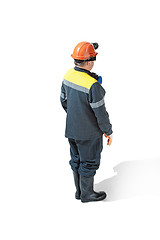 Image showing The studio shot of senior bearded male miner standing at the camera on a white background.