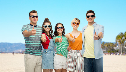 Image showing happy friends showing thumbs up over venice beach