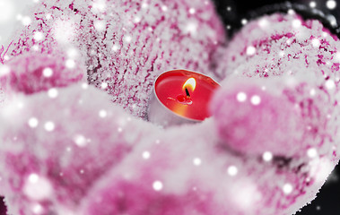 Image showing close up of hands in winter mittens holding candle