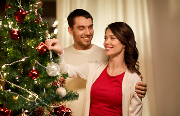 Image showing happy couple decorating christmas tree at home