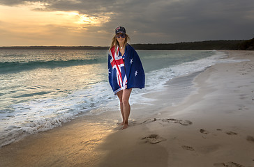 Image showing Woman draped in Australian Flag on a beach in early morning