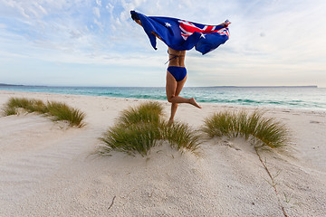 Image showing Woman running and leaping with Australian Flag