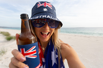 Image showing Australian culture - lazy day on beach girl with a beer