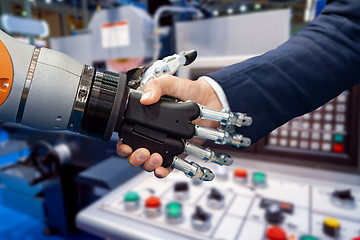 Image showing Hand of a businessman shaking hands with a Android robot.