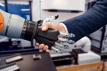 Image showing Hand of a businessman shaking hands with a Android robot.