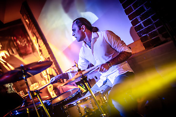 Image showing Drummer playing on drum set on stage.