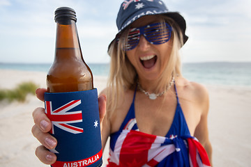 Image showing Australian woman holding offering a bottle of beer