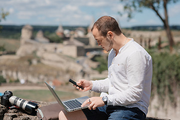 Image showing Handsome businessman with laptop talking on the phone