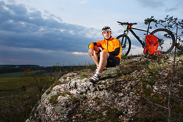 Image showing guy has a rest sitting near his bike