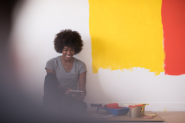 Image showing back female painter sitting on floor