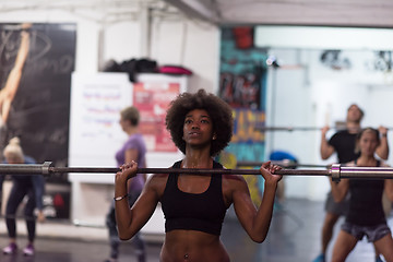 Image showing black woman lifting empty bar