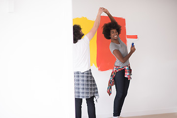 Image showing multiethnic couple painting interior wall