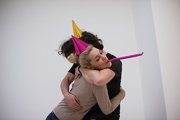 Image showing couple in party hats blowing in whistle