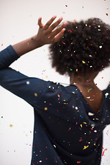 Image showing African American woman blowing confetti in the air