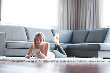 Image showing young women using tablet computer on the floor