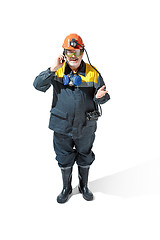 Image showing The studio shot of senior bearded male miner standing at the camera on a white background.