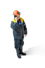 Image showing The studio shot of senior bearded male miner standing at the camera on a white background.