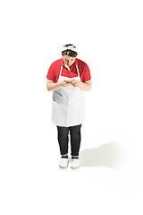 Image showing Portrait of cute smiling woman with mobile phone in her hands in the studio, isolated on white background