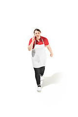 Image showing Portrait of cute smiling woman with mobile phone in her hands in the studio, isolated on white background