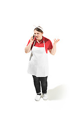 Image showing Portrait of cute smiling woman with mobile phone in her hands in the studio, isolated on white background