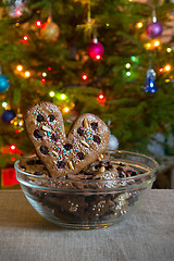 Image showing Gingerbread heart on decorated spruce background.