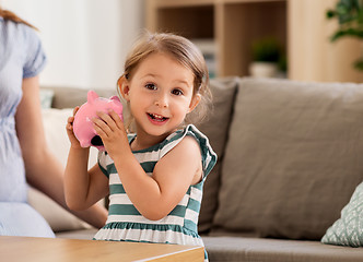Image showing happy little girl with piggy bank