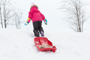 Image showing little girl with sleds on snow hill in winter