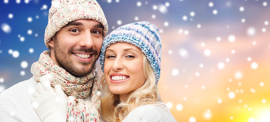 Image showing smiling couple in sweaters over snow background