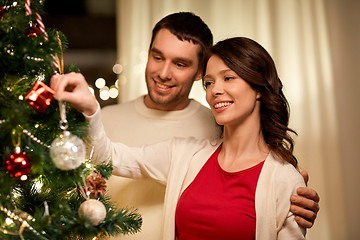 Image showing happy couple decorating christmas tree at home