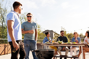 Image showing happy friends having bbq party on rooftop