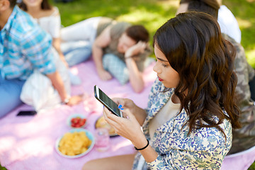 Image showing woman using smartphone at picnic with friends