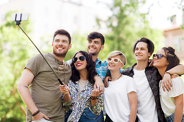 Image showing friends taking picture by selfie stick at summer