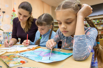 Image showing The teacher helps the students in drawing class