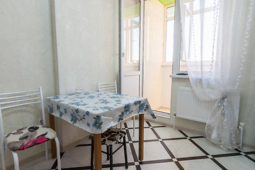 Image showing A small kitchen table stands near the balcony