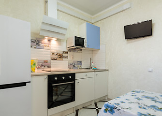 Image showing The interior of a small kitchen with a TV on the wall