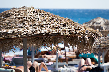 Image showing beach with umbrellas and deck chairs by the sea in Santorini