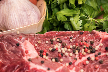 Image showing steak of beef on a wooden board with spices pepper parsley salt 