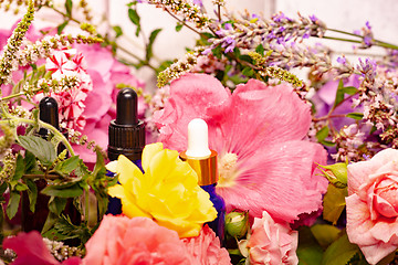 Image showing flowers and bottles of essential oils for aromatherapy